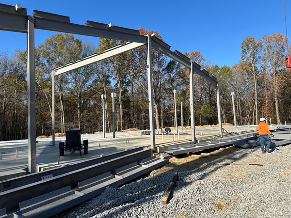 Structural steel framing erected on a finished concrete slab for the new Activity Center building