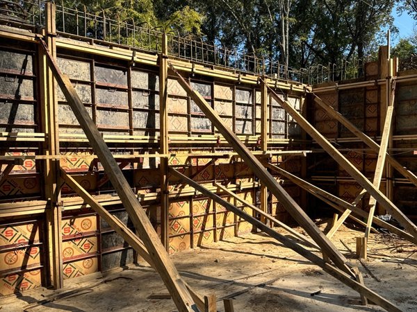 Formwork and bracing set for a concrete foundation wall pour, with vertical rebar dowels in place along the top