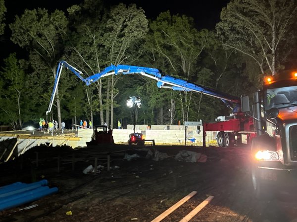 Concrete pump truck positioned for a nighttime slab pour at the Youth Villages campus