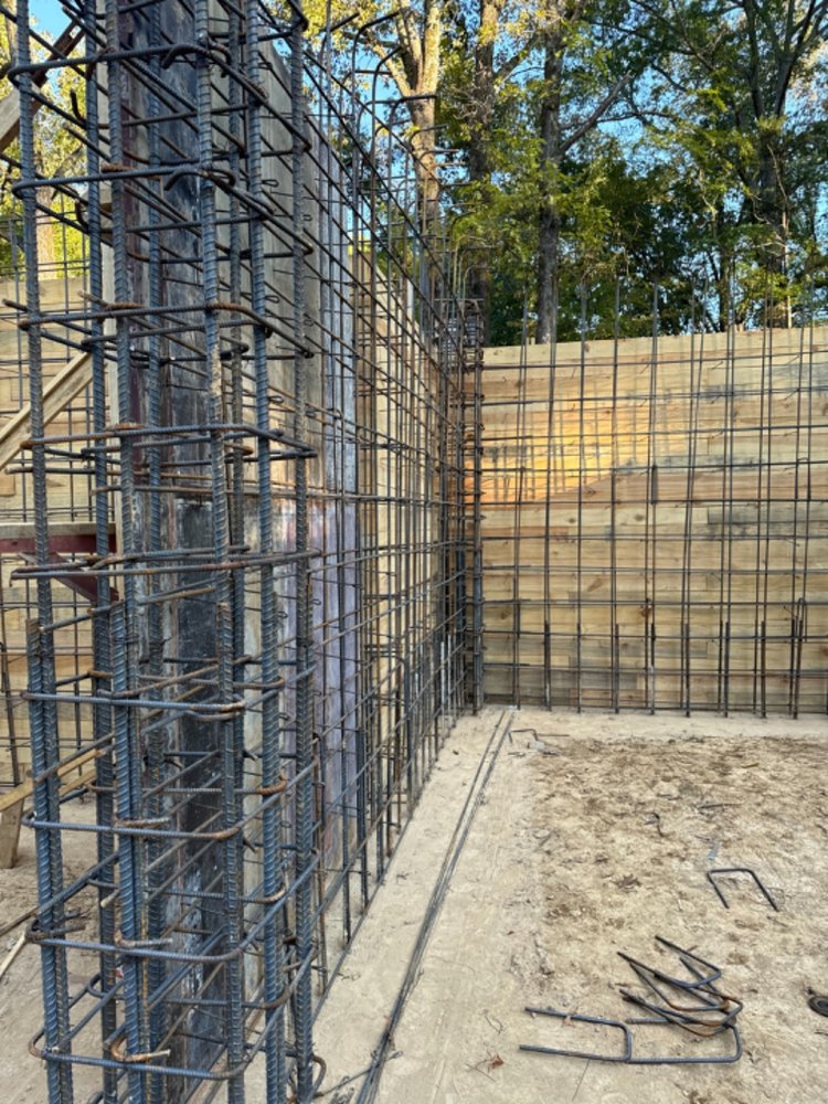 Dense rebar reinforcement for an engineered concrete wall with a custom plank-stamped design.